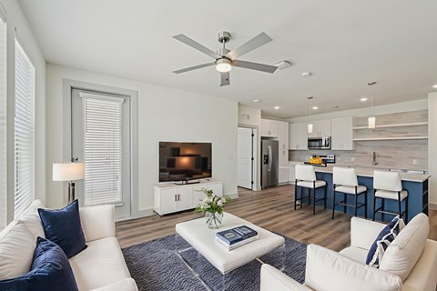 A living room with a white couch and a ceiling fan.